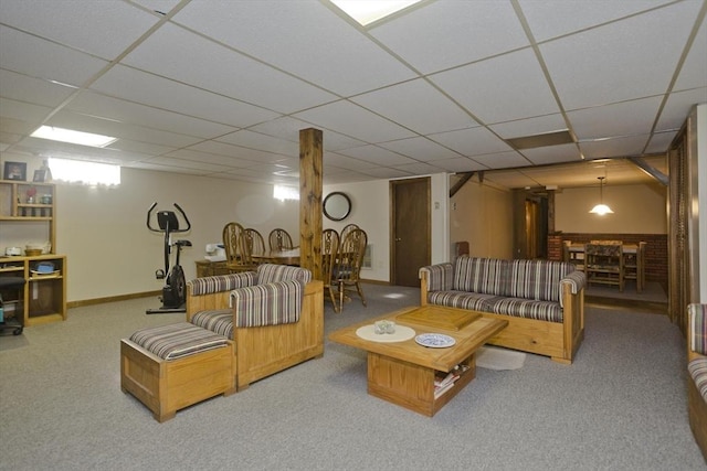 living area with carpet flooring, a paneled ceiling, and baseboards