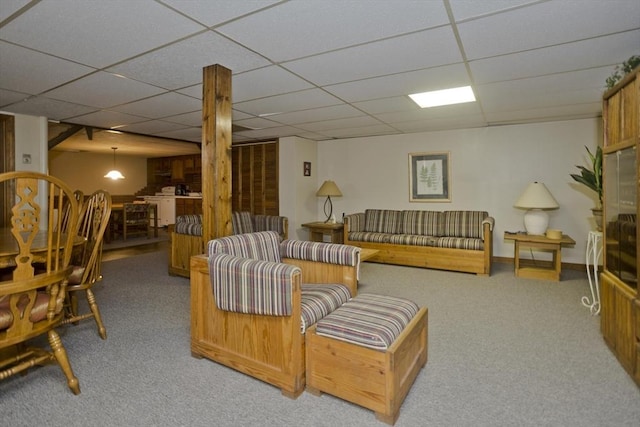 carpeted living area featuring a drop ceiling