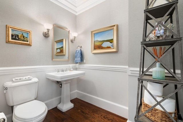 bathroom with toilet, crown molding, baseboards, and wood finished floors