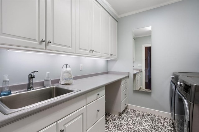 clothes washing area featuring a sink, baseboards, ornamental molding, independent washer and dryer, and cabinet space