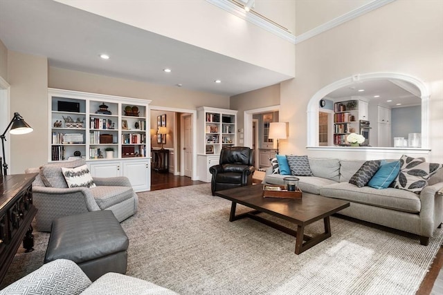 living area featuring recessed lighting, a high ceiling, and wood finished floors