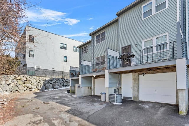 5257 Washington St Unit 5257, Boston, MA 02132 - rear view of house with a balcony, an attached garage, and central air condition unit