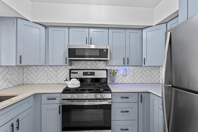 5257 Washington St Unit 5257, Boston, MA 02132 - kitchen with stainless steel appliances, backsplash, and light stone countertops