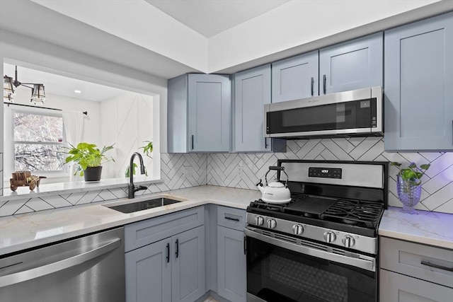 5257 Washington St Unit 5257, Boston, MA 02132 - kitchen with appliances with stainless steel finishes, a sink, gray cabinets, and backsplash