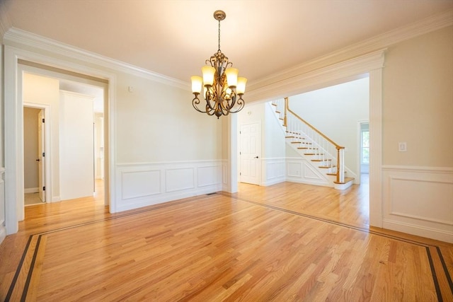 2 Pine Ridge Ln, Mattapoisett, MA 02739 - unfurnished dining area featuring a chandelier, stairway, light wood-type flooring, crown molding, and a wainscoted wall
