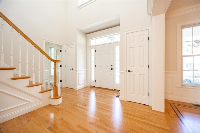 2 Pine Ridge Ln, Mattapoisett, MA 02739 - entryway with a decorative wall, light wood-style flooring, a wainscoted wall, stairs, and ornamental molding