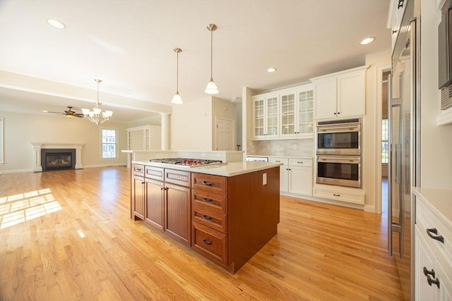 2 Pine Ridge Ln, Mattapoisett, MA 02739 - kitchen featuring appliances with stainless steel finishes, light countertops, light wood-style flooring, glass insert cabinets, and white cabinetry