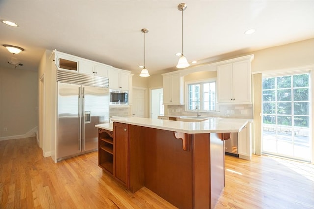 2 Pine Ridge Ln, Mattapoisett, MA 02739 - kitchen featuring built in appliances, a sink, light countertops, a center island, and light wood finished floors