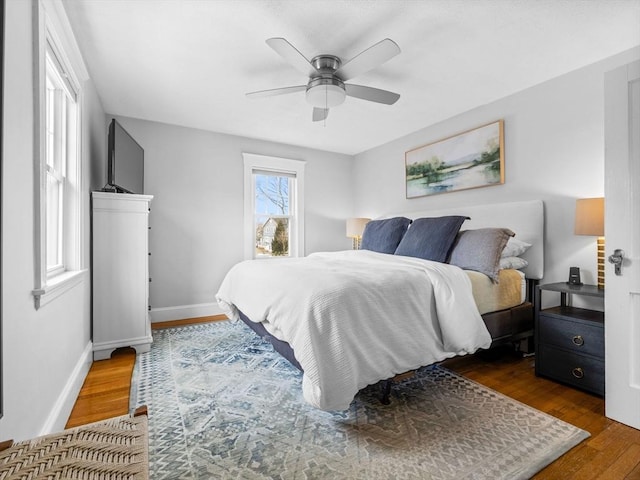 bedroom featuring a ceiling fan, wood finished floors, and baseboards