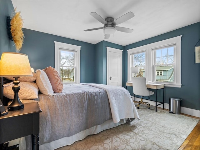 bedroom with ceiling fan, a closet, baseboards, and wood finished floors