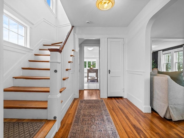 foyer entrance featuring a wealth of natural light, arched walkways, and a decorative wall