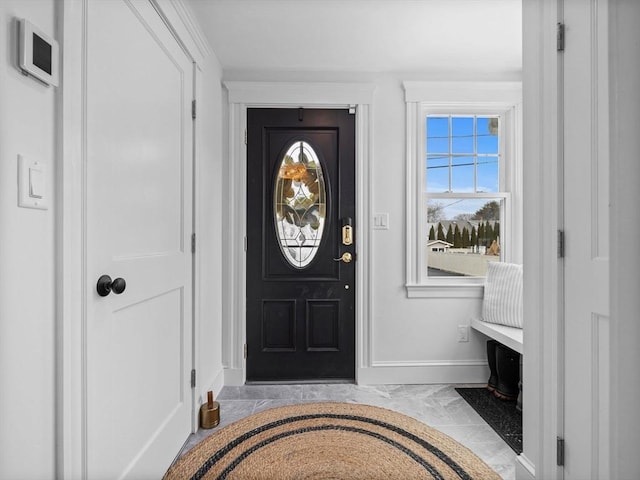 foyer with marble finish floor and baseboards