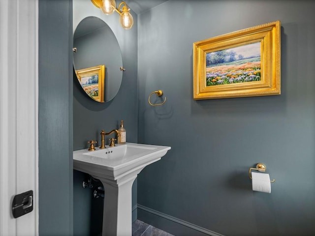 bathroom featuring baseboards and a sink