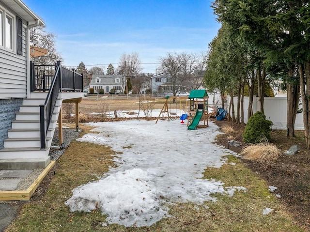 view of yard featuring stairway, a playground, fence, and a wooden deck