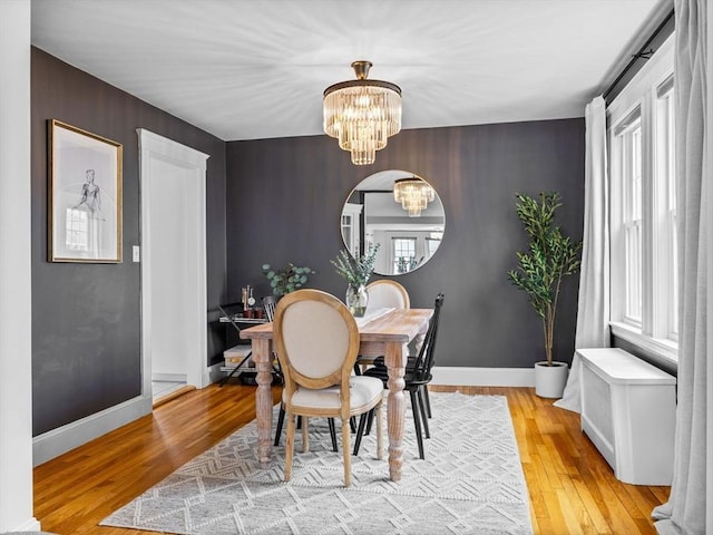 dining room with plenty of natural light, light wood-style floors, and a chandelier