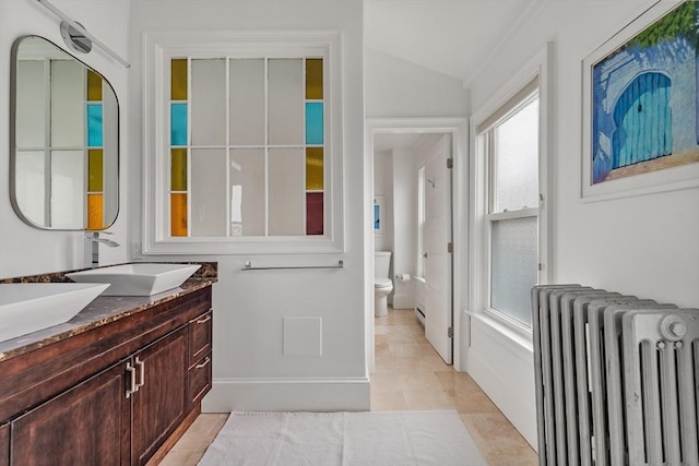 17 Atlantic St, Boston, MA 02127 - bathroom with radiator heating unit, vanity, toilet, vaulted ceiling, and tile patterned flooring