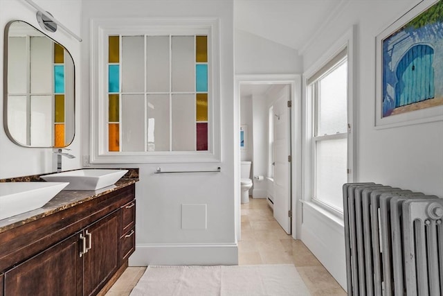 17 Atlantic St, Boston, MA 02127 - full bath with radiator heating unit, vanity, toilet, lofted ceiling, and tile patterned flooring
