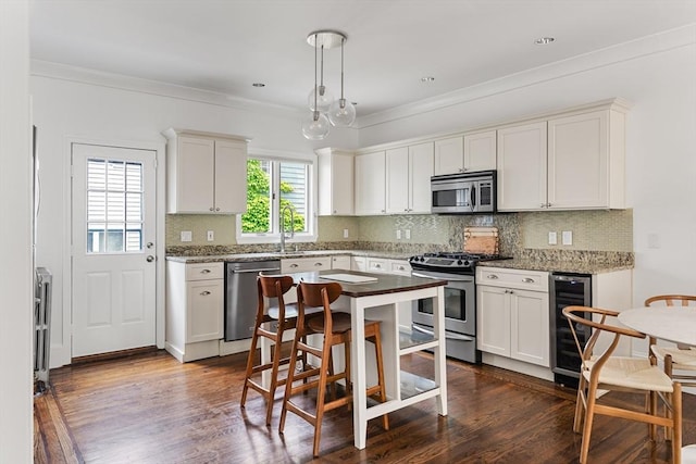 17 Atlantic St, Boston, MA 02127 - kitchen with appliances with stainless steel finishes, beverage cooler, decorative backsplash, dark wood-type flooring, and ornamental molding