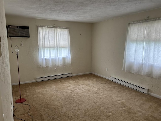 188 Swanson Rd Unit 331, Boxborough, MA 01719 - spare room featuring baseboard heating, a baseboard radiator, carpet, an AC wall unit, and a textured ceiling