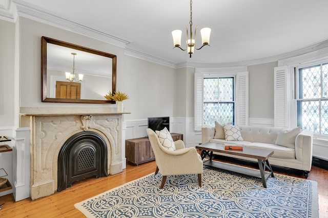 living room featuring wood-type flooring, a notable chandelier, and ornamental molding