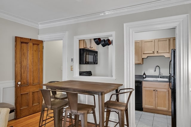 dining room with light hardwood / wood-style flooring, crown molding, and sink