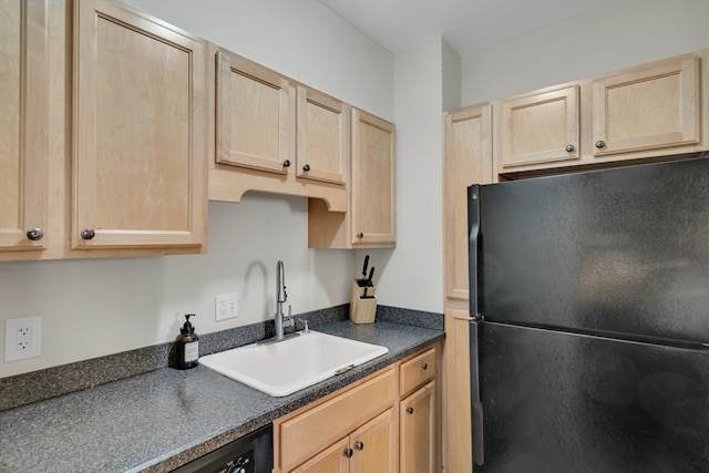 kitchen featuring black appliances, light brown cabinetry, and sink