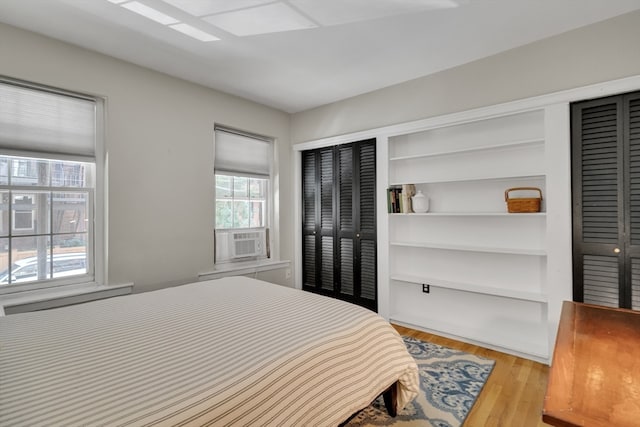 bedroom featuring cooling unit, multiple windows, and light hardwood / wood-style flooring