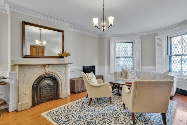 living room featuring ornamental molding, hardwood / wood-style floors, and an inviting chandelier