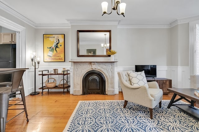 living room featuring wood-type flooring, an inviting chandelier, and ornamental molding