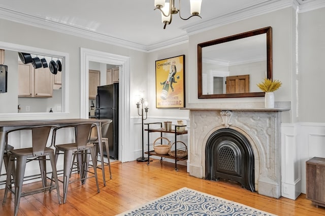 living room with ornamental molding, a notable chandelier, and light hardwood / wood-style floors