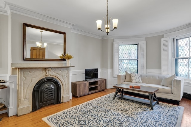 living room featuring a wealth of natural light, ornamental molding, an inviting chandelier, and hardwood / wood-style flooring