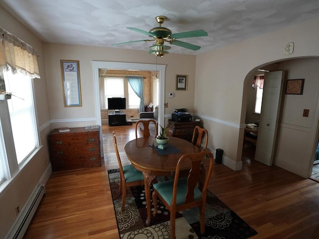 95AKA93 Lynnway, Revere, MA 02151 - dining area featuring a baseboard radiator, arched walkways, ceiling fan, and light wood-style flooring
