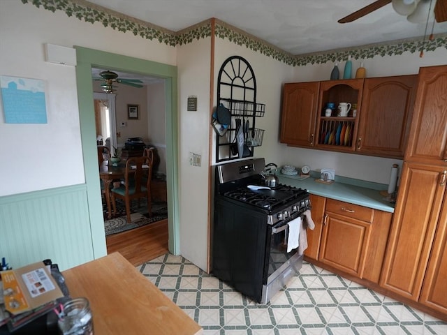 95AKA93 Lynnway, Revere, MA 02151 - kitchen with range with gas stovetop, a ceiling fan, light countertops, brown cabinetry, and a wainscoted wall