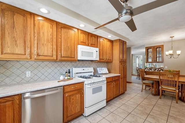 kitchen featuring white appliances, decorative backsplash, brown cabinetry, light countertops, and recessed lighting