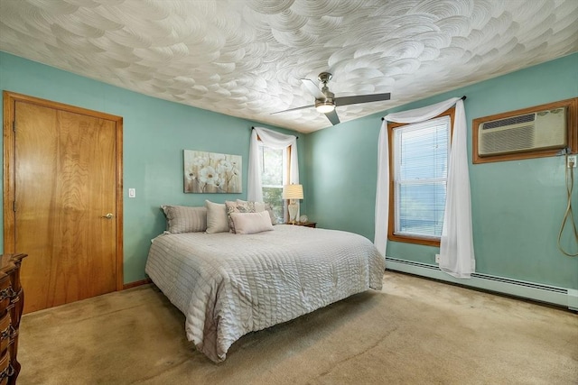 bedroom with carpet, a baseboard heating unit, an AC wall unit, and a ceiling fan
