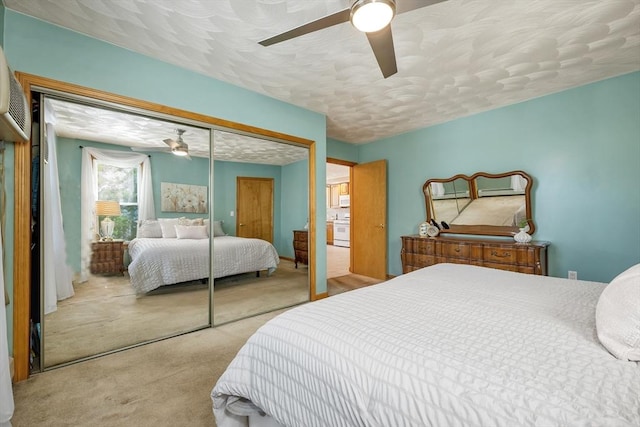carpeted bedroom with a closet, a ceiling fan, and a textured ceiling