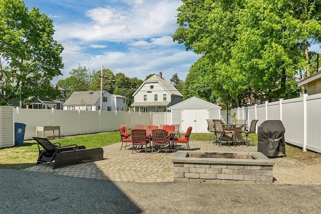 view of patio featuring outdoor dining space, a shed, an outbuilding, and a fenced backyard