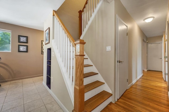 staircase with baseboards and wood finished floors