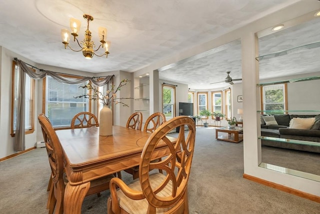 carpeted dining space featuring plenty of natural light, a chandelier, baseboards, and a ceiling fan