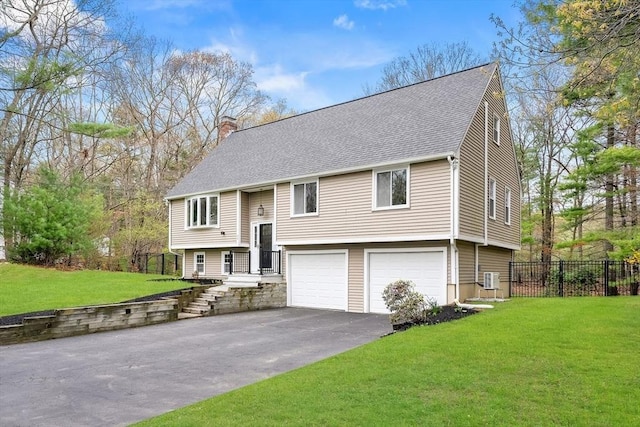 split foyer home with fence, a shingled roof, a garage, a chimney, and driveway