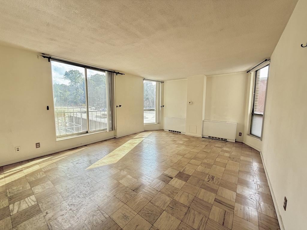 77 Pond Ave Unit 312, Brookline, MA 02445 - empty room featuring a textured ceiling and radiator