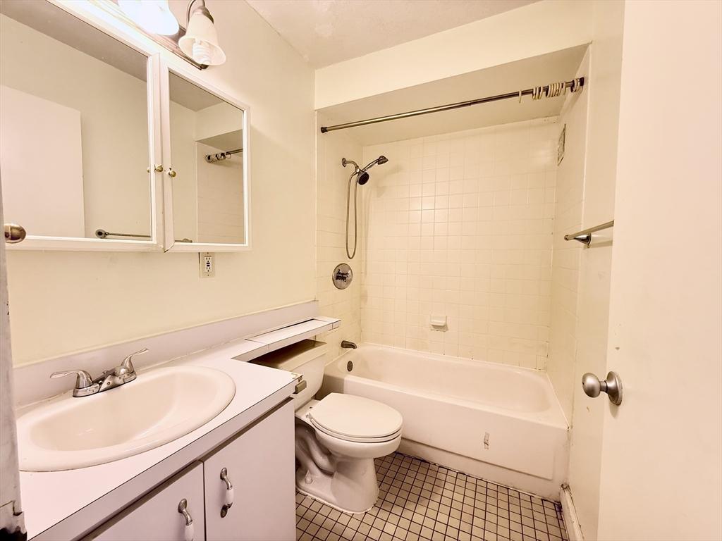 77 Pond Ave Unit 312, Brookline, MA 02445 - full bathroom featuring vanity, tile patterned floors, and washtub / shower combination