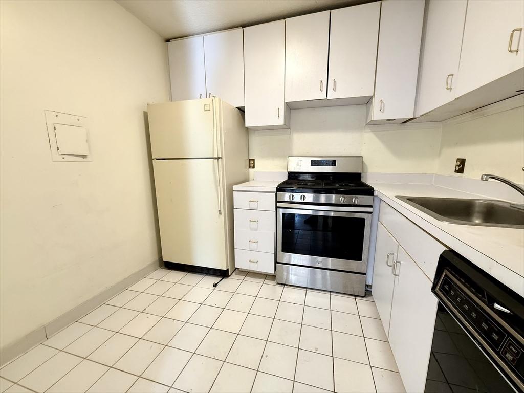 77 Pond Ave Unit 312, Brookline, MA 02445 - kitchen featuring stainless steel range with gas stovetop, freestanding refrigerator, black dishwasher, and light countertops