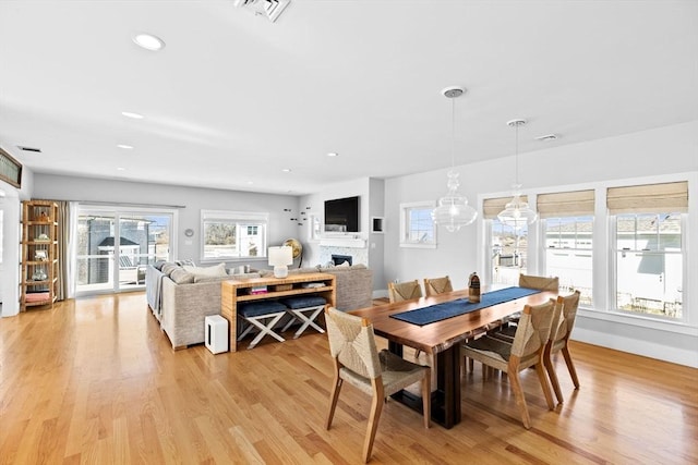 dining room with recessed lighting, visible vents, light wood-style flooring, and a fireplace