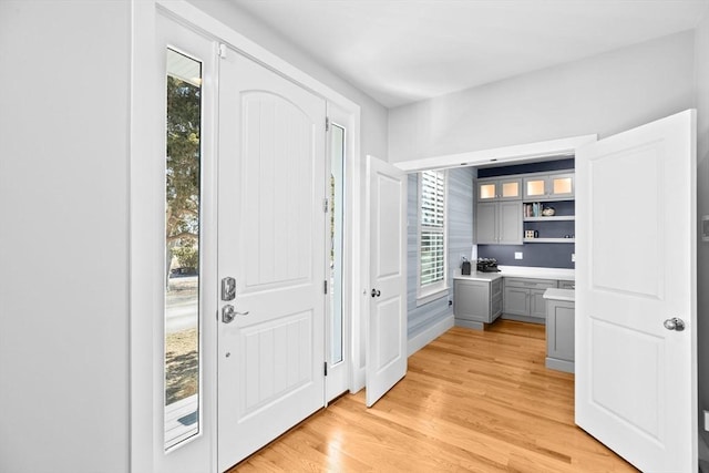 entrance foyer featuring light wood finished floors, a healthy amount of sunlight, and built in study area