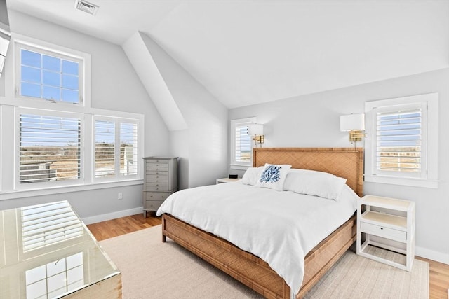 bedroom with visible vents, multiple windows, and wood finished floors