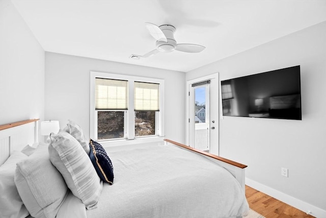 bedroom featuring baseboards, wood finished floors, and a ceiling fan