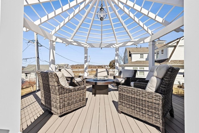 wooden terrace with an outdoor living space with a fire pit and a pergola