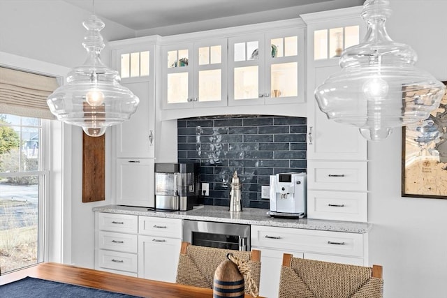 kitchen with decorative backsplash, white cabinets, and glass insert cabinets