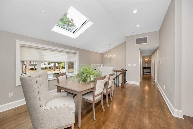 dining space featuring lofted ceiling with skylight, dark wood-type flooring, and a chandelier